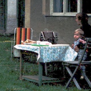 Children playing outside an old, weathered house.