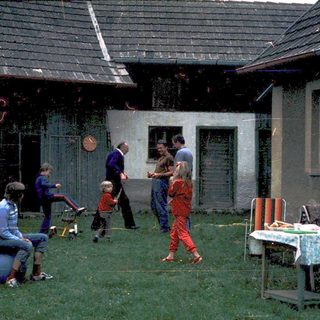 Children playing outside an old, weathered house.