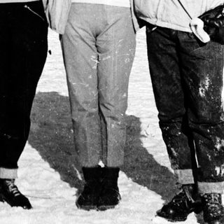 Five people posing together outdoors in winter clothing.