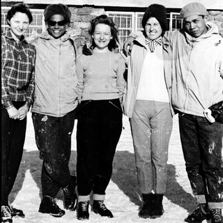 Five people posing together outdoors in winter clothing.