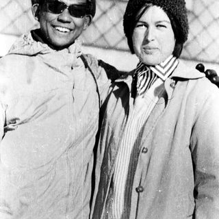 Two people posing together outdoors in winter attire.