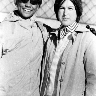 Two people posing together outdoors in winter attire.
