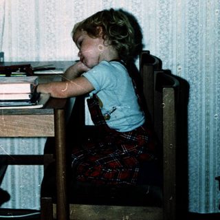 Two children studying together at a table indoors.