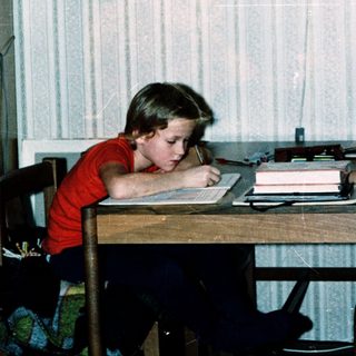 Two children studying together at a table indoors.