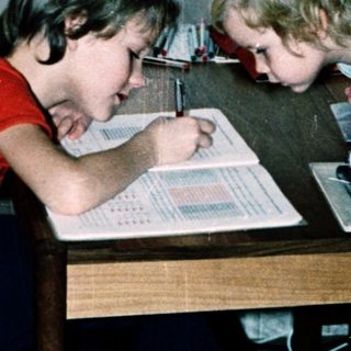 Two children studying together at a table.