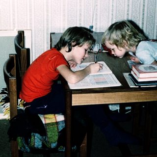 Two children studying together at a table.