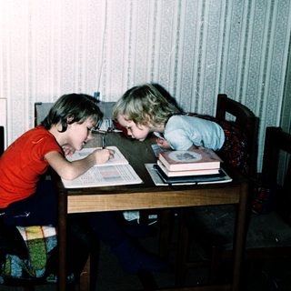 Two children studying together at a table.