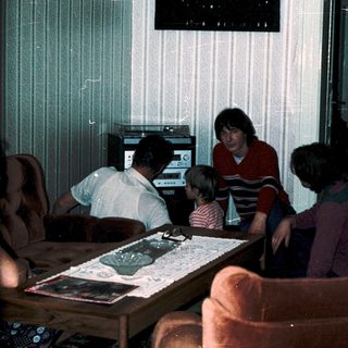 Family playing video game together in living room.