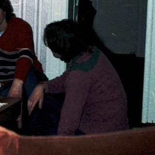 Family playing video game together in living room.