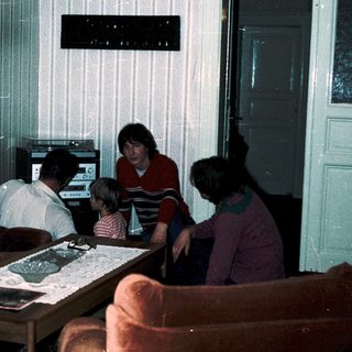 Family playing video game together in living room.