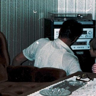 Family playing video game together in living room.