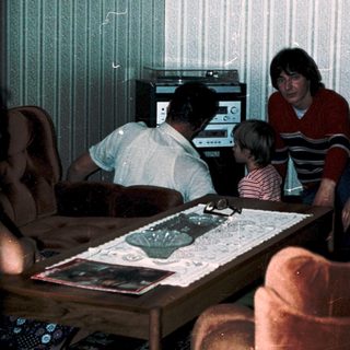 Family playing video game together in living room.
