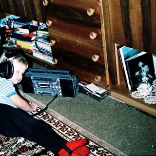 Child listening to music with headphones on floor.