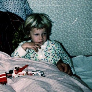 Family sharing bed with children at night.