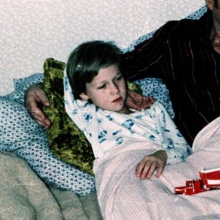 Family sharing bed with children at night.