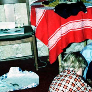 Two children playing with a toy train set.