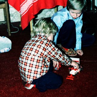 Two children playing with a toy train set.