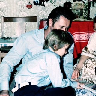 Family playing board game indoors during holiday season.