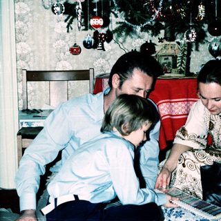 Family playing board game indoors during holiday season.