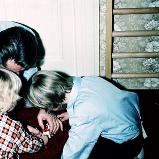 Family members gathered closely indoors, embracing affectionately.