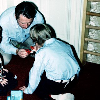 Family playing board game indoors together.