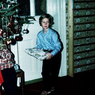 Two children standing near a decorated Christmas tree.