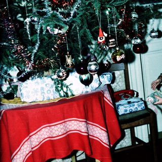 Child decorating Christmas tree with ornaments.