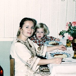 Family dining together indoors during the 1980s.