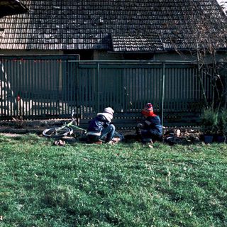 Person lying on grass beside fallen motorcycle.