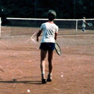 A person playing frisbee in an open dirt field.