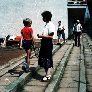 Urban corridor with woman and child walking.