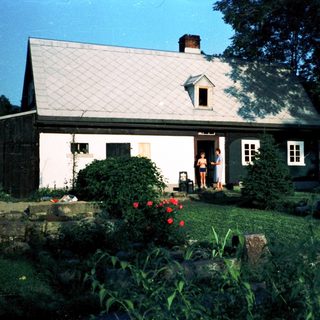 Rural house with person standing in doorway.
