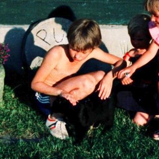 Family playing outside near a house at night.
