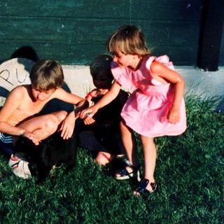 Family playing outside near a house at night.