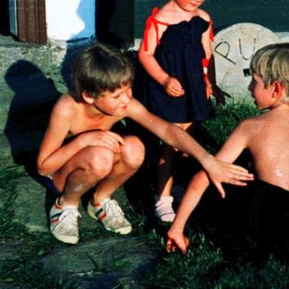 Four children playing outside near a house.