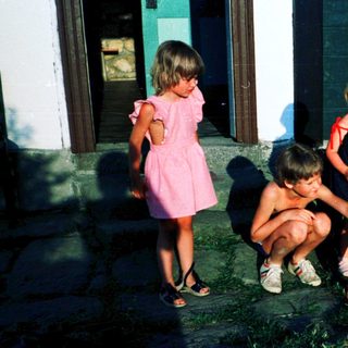 Four children playing outside near a house.