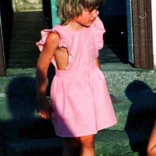Four children playing outside near a house.
