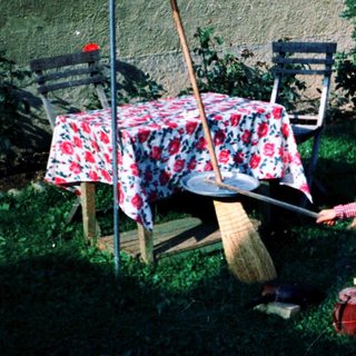 Two children playing outside with gardening tools.