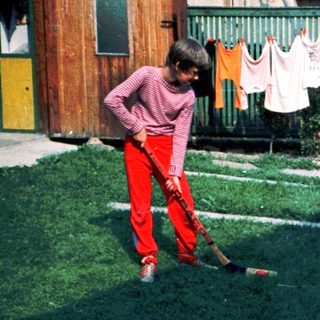 Two children playing with baseball bats outdoors.