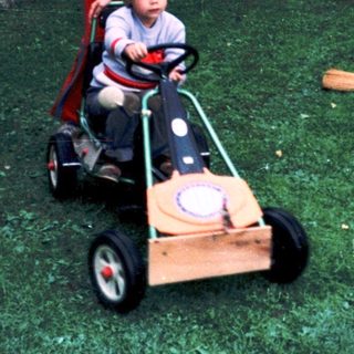 Two children playing with toy cars in courtyard.