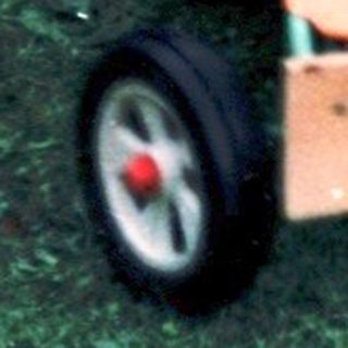 Two children playing with toy cars in courtyard.