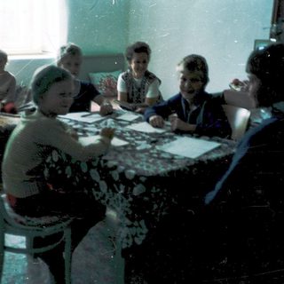 Group playing board games indoors, mid-20th century.