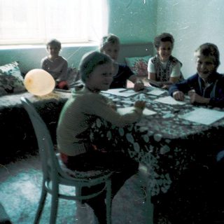 Group playing board games indoors, mid-20th century.