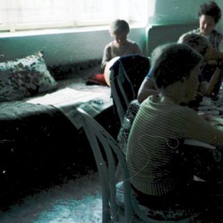 Family gathering indoors around a table.