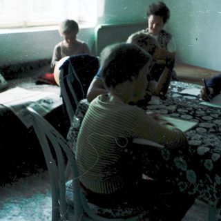 Family gathering indoors around a table.