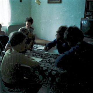 Family gathering indoors around a table.