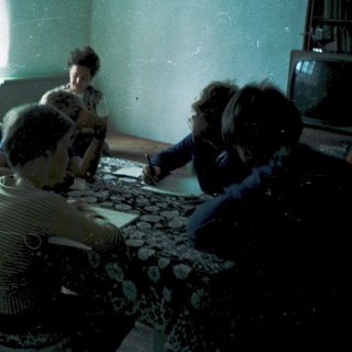 Family gathering indoors around a table.