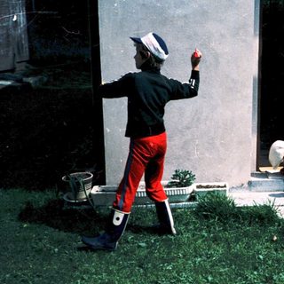 Two people tending graves in cemetery.