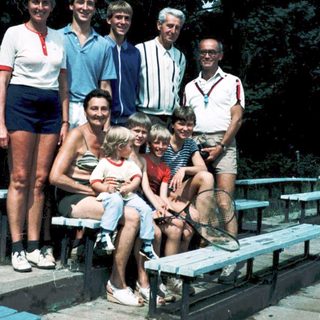 Family group photo outdoors in summer attire.