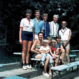Family group photo outdoors in summer attire.